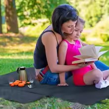 maman et sa fille sur tapis de coffre voiture luxe au parc