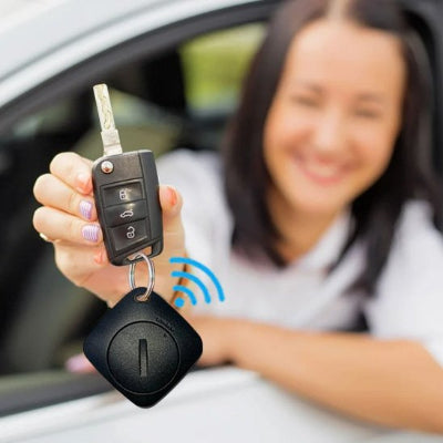 Conductrice souriante présentant son traceur gps voiture relatif